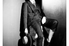 Cinematic black and white portrait with suit and hat